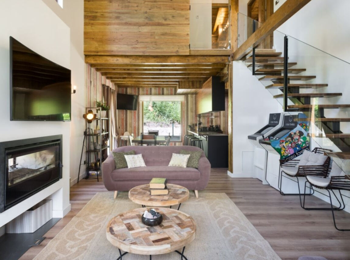 Interior de doble altura con revestimiento de madera y escalera volada